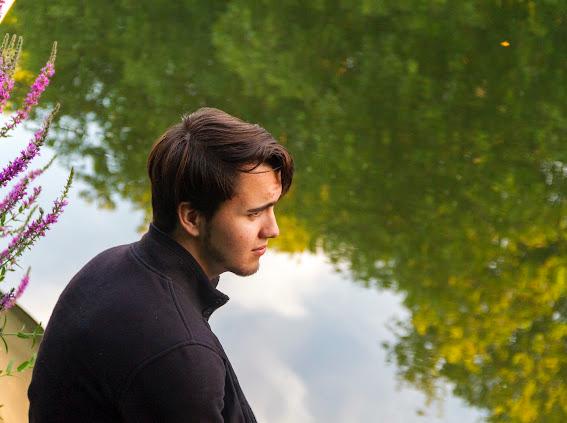 Austin Coveney sitting by a river looking out across the water